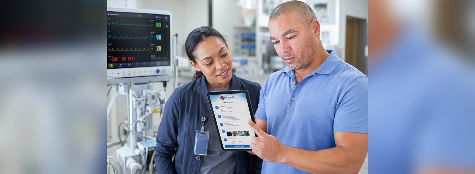 Clinician signing a digital service report in the BiomedRx App beside a patient monitor